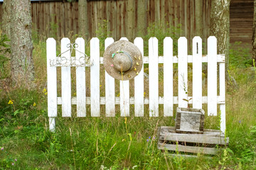 White wooden sabol in Deorevenskoy cottage. Fence hat on the fence, retro style. Countryside....