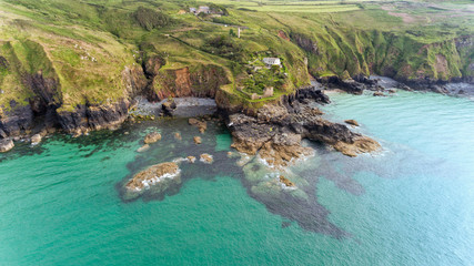 Fototapeta na wymiar Aerial view of Cornish coastline with high cliffs, rocky shore, stone beaches, coastal footpaths near St Ives, Cornwall, south west England, on a cloudy summer day .