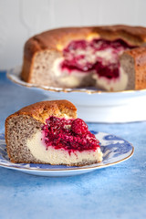 close up view of slice of raspberry cream cake with rest of cake in the background