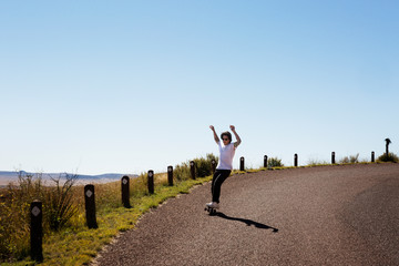 Young man skateboarding along country road © Cavan for Adobe