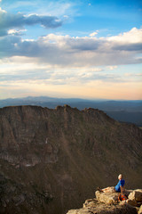 Fototapeta premium Mature man on cliff overlooking mountain range