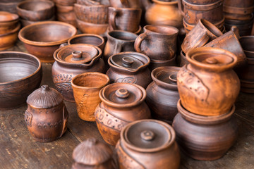 Fototapeta na wymiar Pottery: pots and cups at the exhibition. The concept of the fair, handmade art and craft.