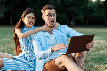 young couple with laptop in the park