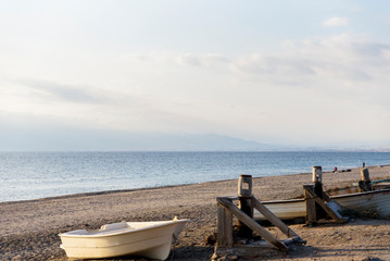 wooden boats stranded on the shore of the sea sunset