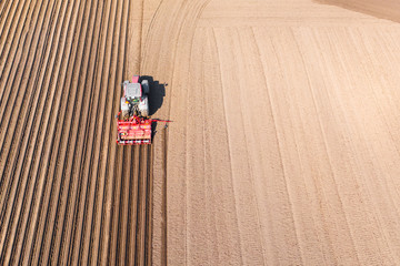 Tractor on a plowed field, top view. Agricultural field for planting vegetables. Tractor makes...