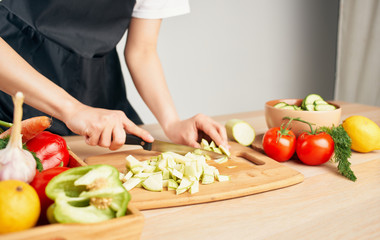 Obraz na płótnie Canvas woman cutting vegetables in the kitchen