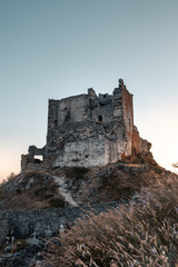 Fototapeta na wymiar ruined castle at the top of the hill in a sunset