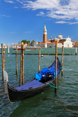 Fototapeta na wymiar Gondola moored near San Marco square across from San Giorgio Maggiore island in Venice, Italy