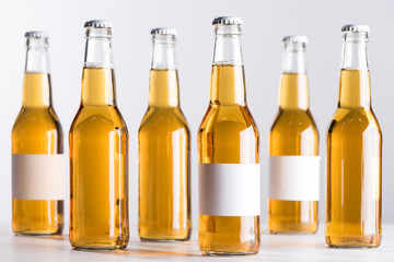 selective focus of beer bottles with blank white labels isolated on grey