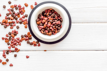 Dry pet food in bowls on white wooden background top view space for text