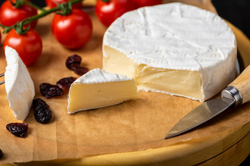 cheese board - camembert cheese with nuts, cranberries and cherry tomatoes