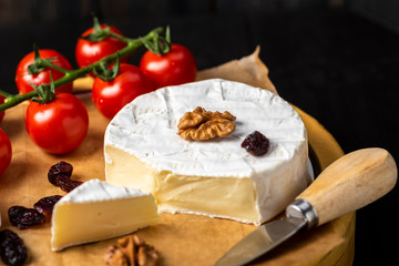 cheese board - camembert cheese with nuts, cranberries and cherry tomatoes