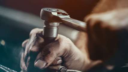 Auto mechanic working on car engine in mechanics garage. Repair service.