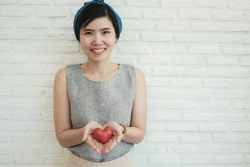 Asian woman holding red heart, health insurance, donation charity concept