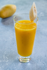 mango passion fruit smoothie on grey concrete