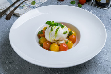 Salad with buratta cheese on white plate