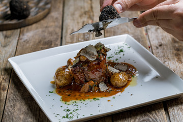 filet Mignon with truffle on white plate on wooden background
