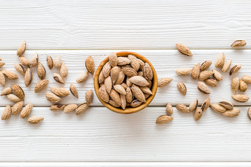 Healthy snack with almonds on white wooden background top view