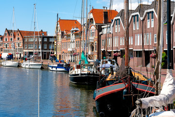 Fototapeta na wymiar Sailing ships and dutch buildings by the Hoofdtooren in Hoorn, Netherlands