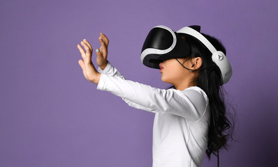 Young girl kid child play virtual reality game wear vr glasses and explore alternative reality. Cyber space and virtual gaming