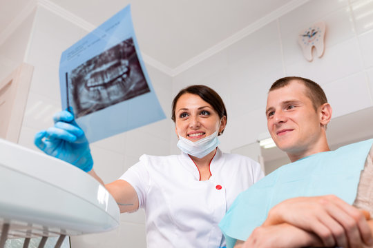 People, medicine, stomatology, technology and health care concept - happy female dentist with teeth x-ray on tablet pc computer and patient girl at dental clinic office