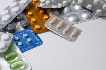 packings of pills and capsules of medicines in different position on white background