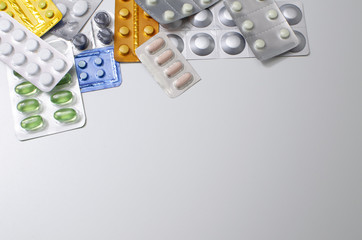 packings of pills and capsules of medicines in different position on white background