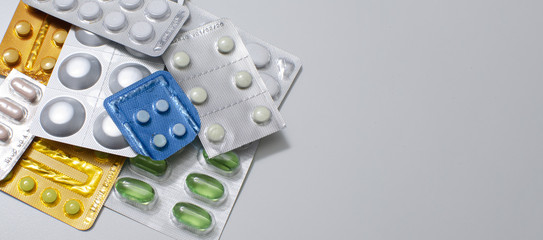 packings of pills and capsules of medicines in different position on white background