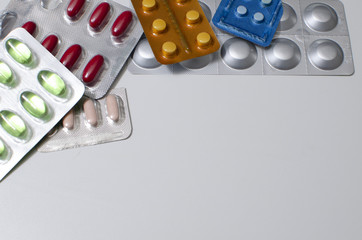 packings of pills and capsules of medicines in different position on white background