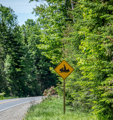 Yellow Street Sign Warning that Snow Mobiles are Driving Over the Street
