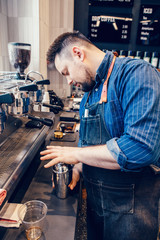 Caucasian handsome bearded man barista making iced coffee cappuccino latte. Waiter server shaking metal silver jar cup to make cold drink. Small business and person at work concept.