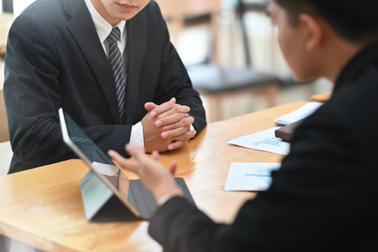 Two businessman meeting and consult with digital portable computer on table.