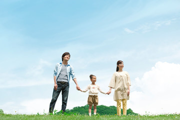 手をつないで立つ家族3人