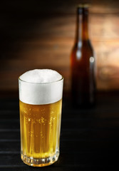 Beer Glass and bottle closeup on a wooden surface background