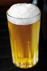 Beer Glass and bottle closeup on a wooden surface background