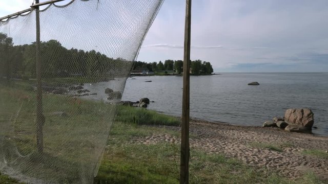 Fishing net at coast of K&auml;smu. Some buildings background. Baltic Sea, Gulf of Finland. Panorama to right.