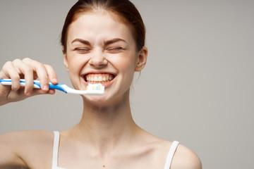 young woman brushing her teeth