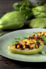 chayote stuffed baked stuffed with minced meat, corn and pieces of the chayot with cheese sauce
