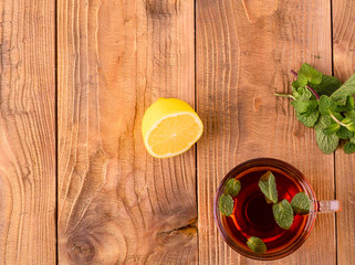 The Cup of tea with mint and lemon on brown wooden table