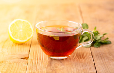 The Cup of tea with mint and lemon on brown wooden table