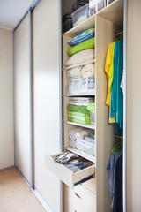 Wardrobe with women's and men's clothing. Drawers with underwear, bed linen, socks and shirts.