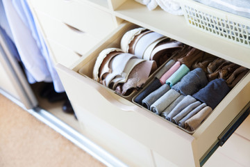 Wardrobe with women's and men's clothing. Drawers with underwear, bed linen, socks and shirts.