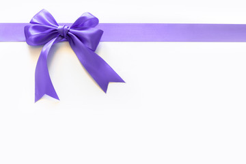 Violet ribbon with a bow as a gift on a white background