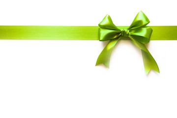 Green ribbon with a bow as a gift on a white background