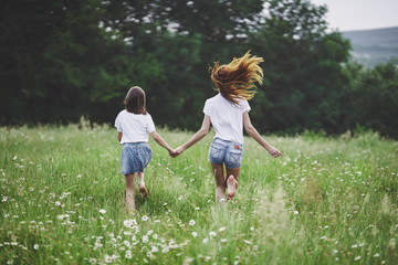 Fototapeta premium mother and daughter running on the meadow