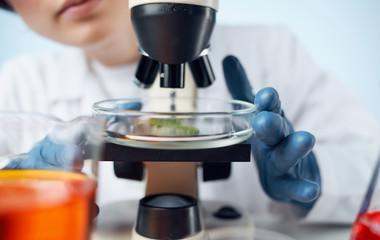 female scientist looking through microscope