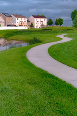 Walkway and pond with bridge in front of homes with outdoor stairs and balconies