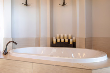 Bathroom interior with close up view of a gleaming oval shaped built in bathtub
