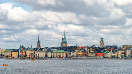 Fototapeta premium Scenic view on Gamla Stan (Old town) in Stockholm from Strommen bay, Sweden, at cloudy spring day.