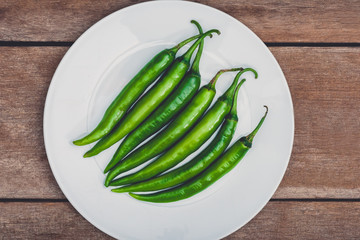 Green chili on wooden table background